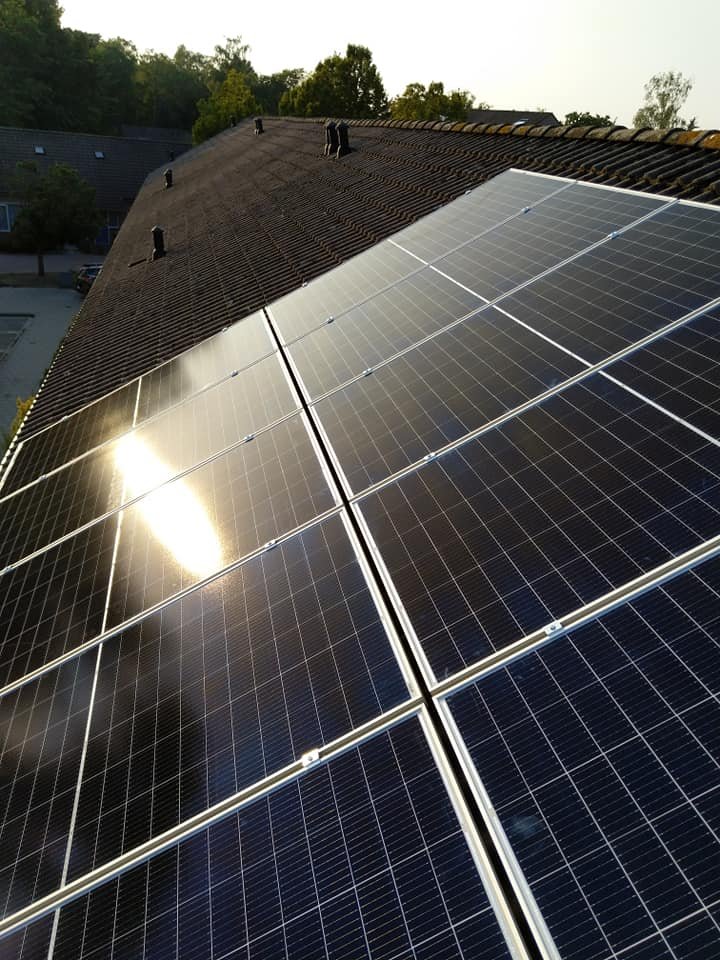 Zonlicht weerkaatst op een net opgeleverd dakvlak met zonnepanelen