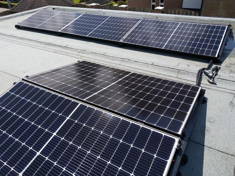 Twee lange rijen zonnepanelen op een bitumen dak