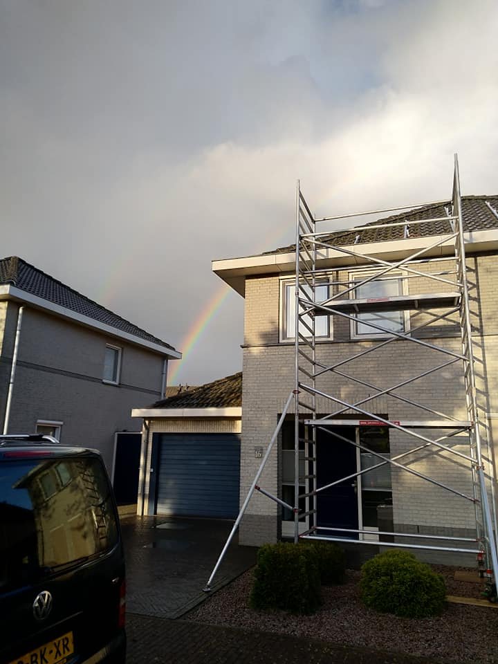 Rolsteiger tegen een woning met een regenboog boven de wijk